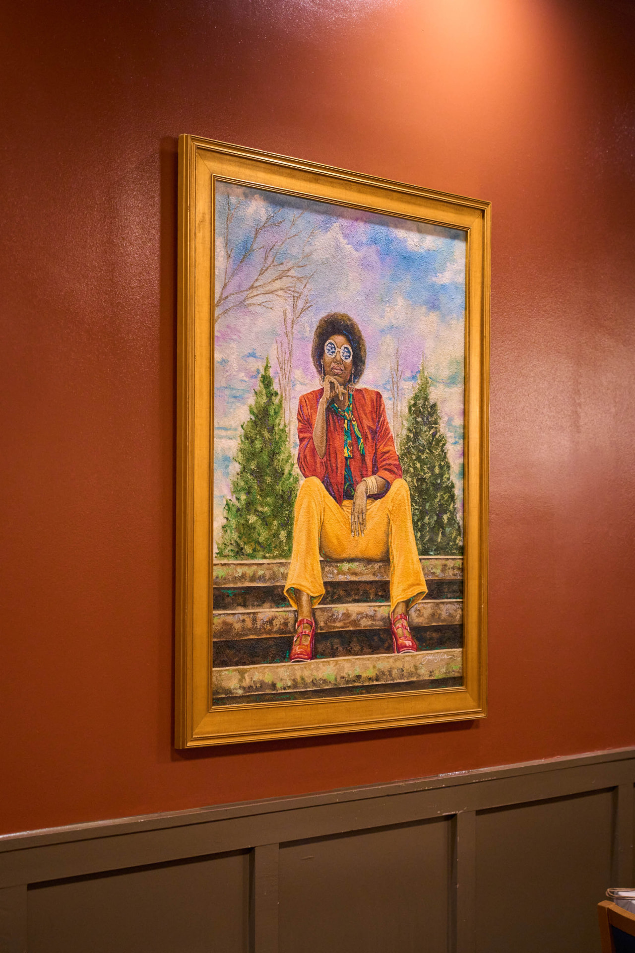 Framed artwork on the burgundy wall of the Eli's Table private dining room in downtown Charleston