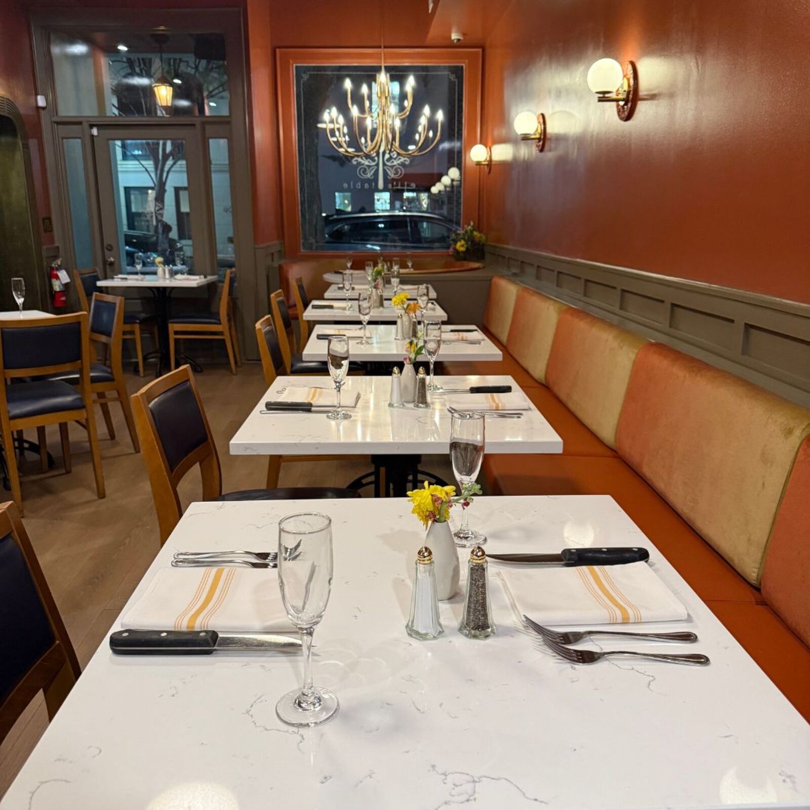 Elegant dining room at Eli's Table in Charleston with warm lighting, banquette seating, and intimate ambiance